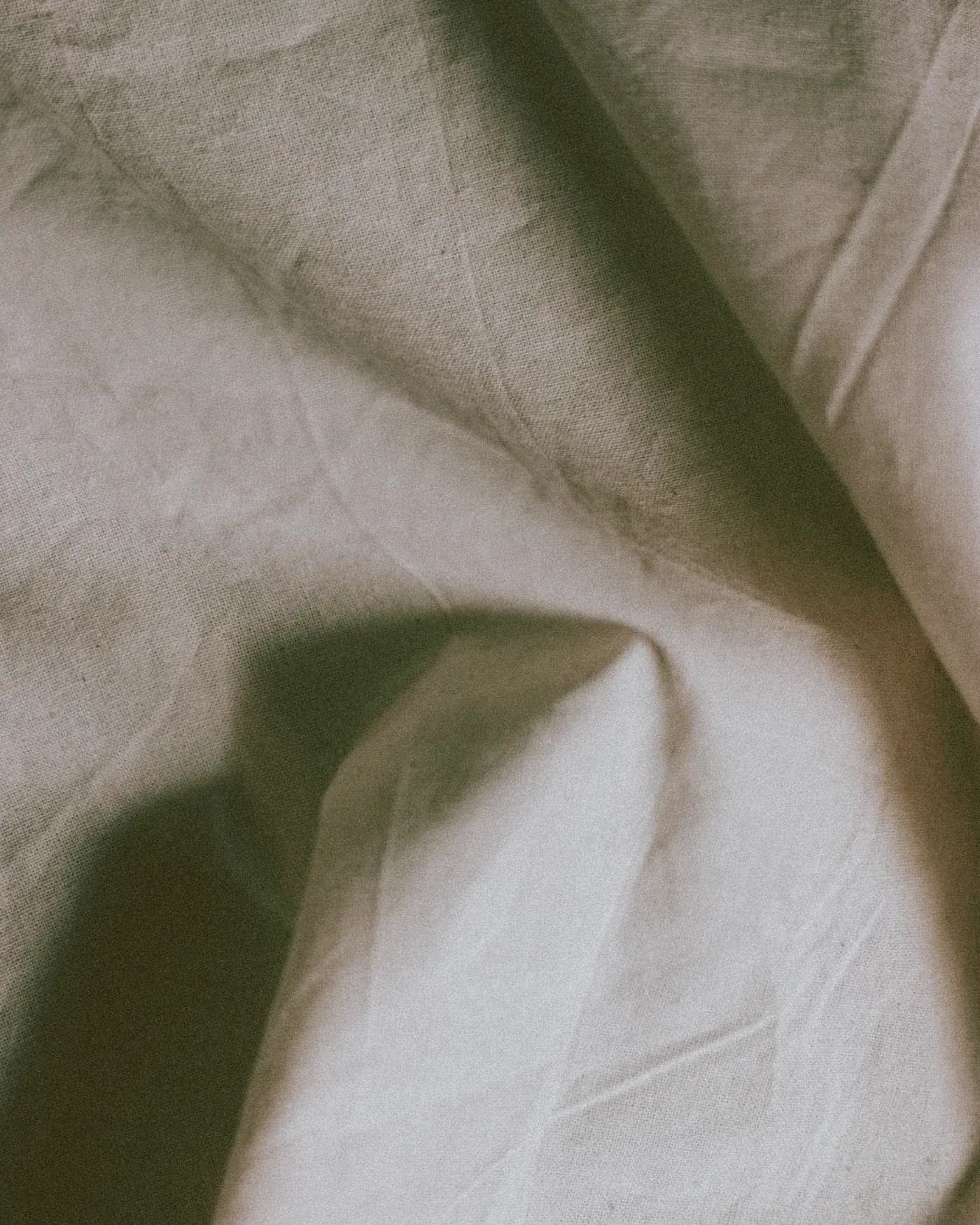 Pale cloth folded in soft light.